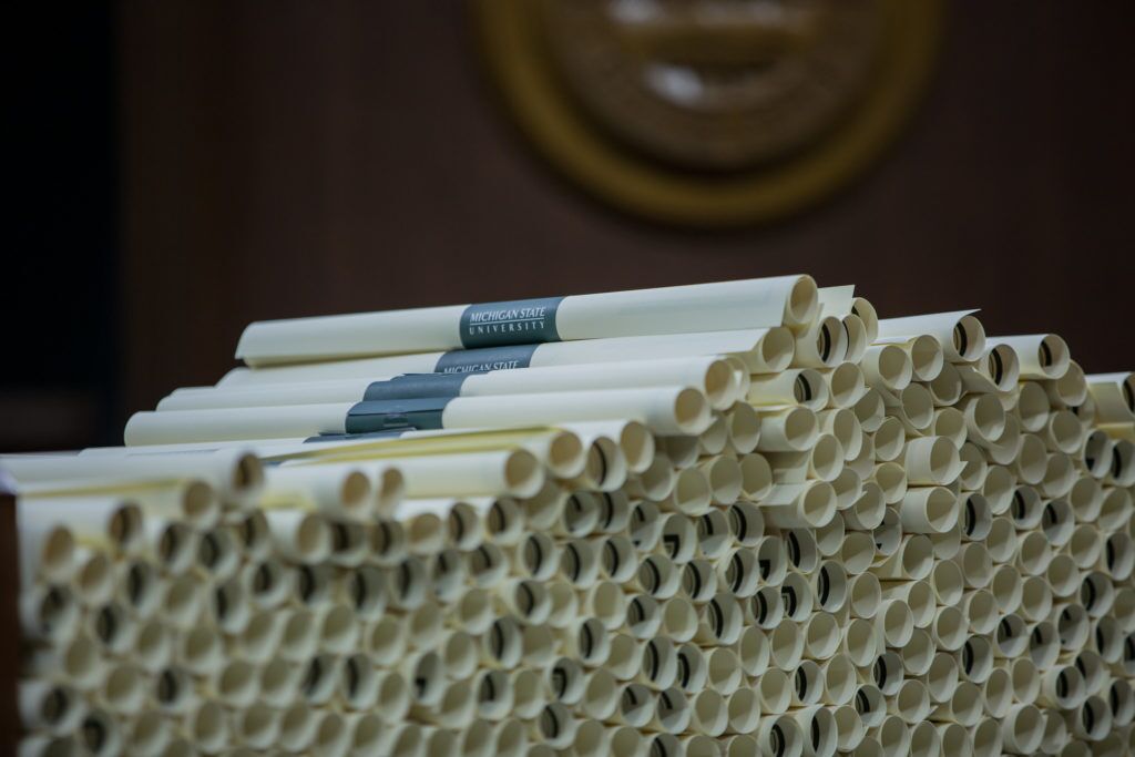 A pile of MSU diplomas at a commencement ceremony.