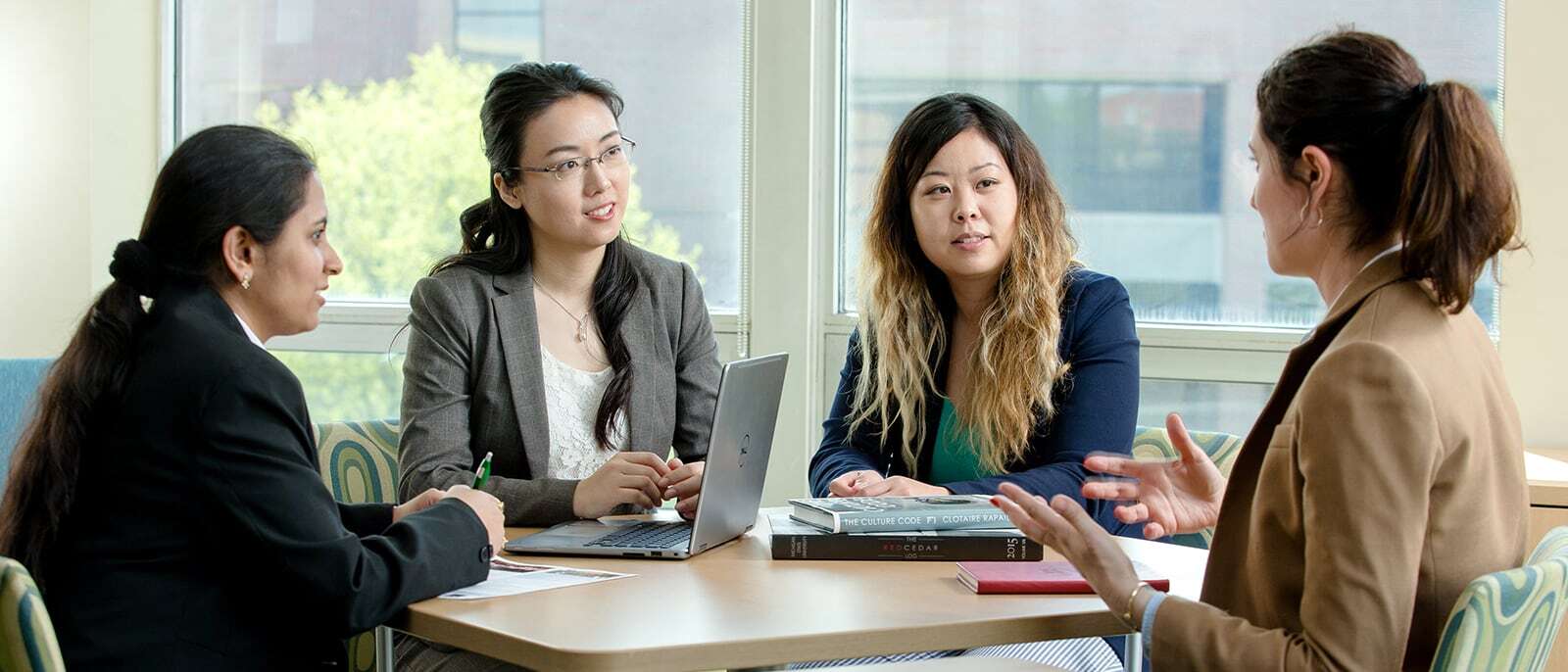 Group of Full-Time MBA students talking at a table