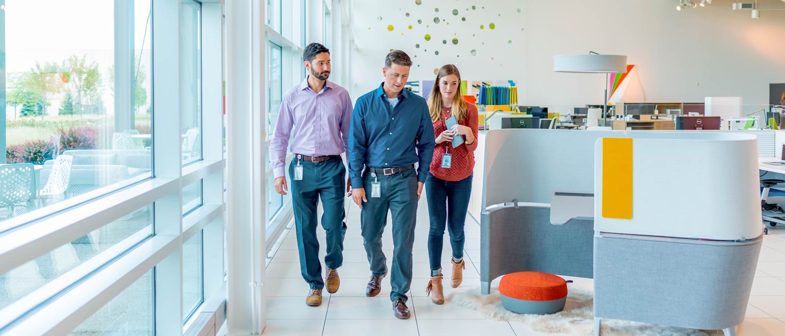 MSU EMBA alum Peter Gillen walks through well-lit office with two colleagues