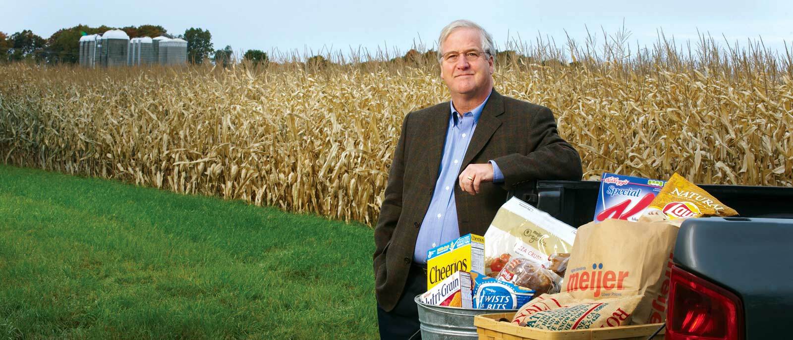 MSU Supply Chain Management faculty member Dave Close poses in a corn field with a truck bed full of groceries.