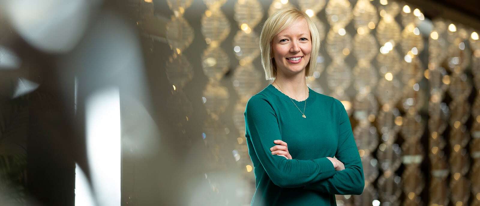 Full-TIme MBA alumna posing in front of a shimmering backdrop.