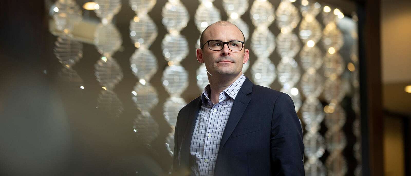 Full-Time MBA student posed with a decorative backdrop of twisted columns made from plastic.