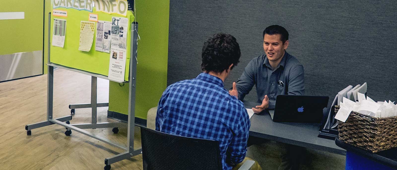 An advisor talks with an RBC student in the engagement center.