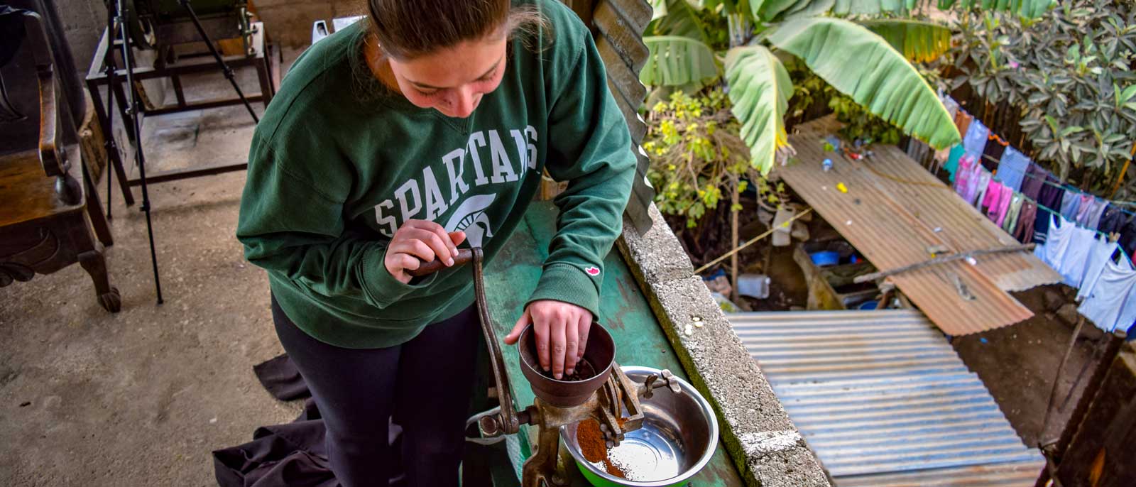 Spartan Global Development Fund student grinds beans.