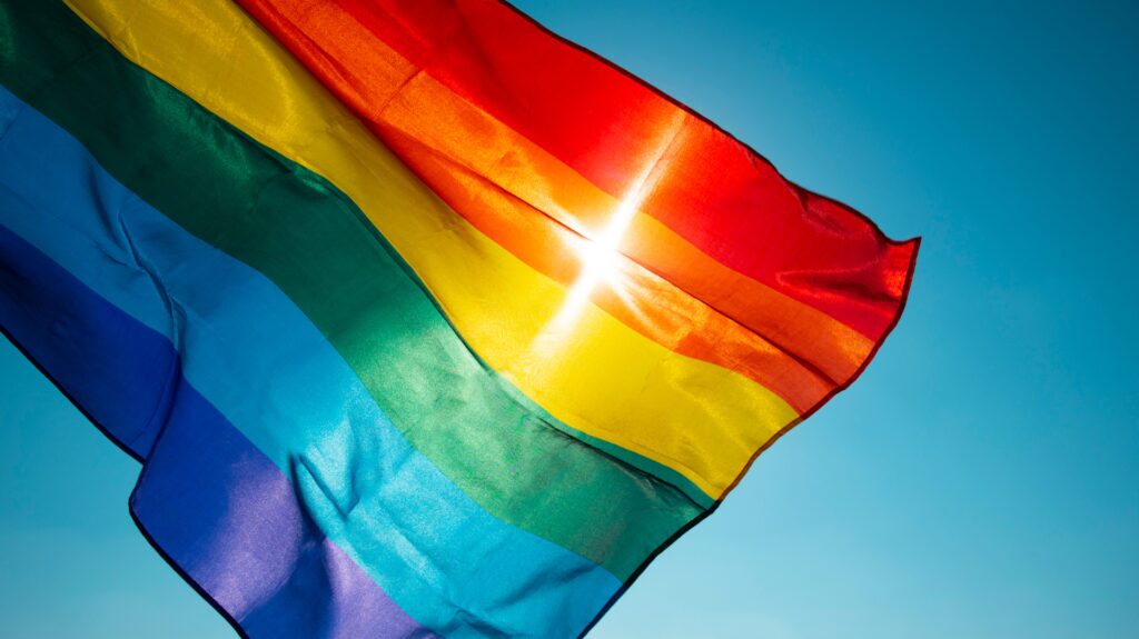 rainbow flag waving on the blue sky