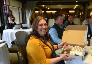 A woman holds a DOC Box, filled with toys and tools for children with developmental challenges.