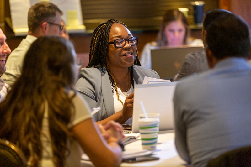 Executive MBA students talk and work together at orientation.