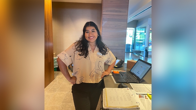 Guadalupe Huapilla-Perez standing behind a Hotel concierge desk