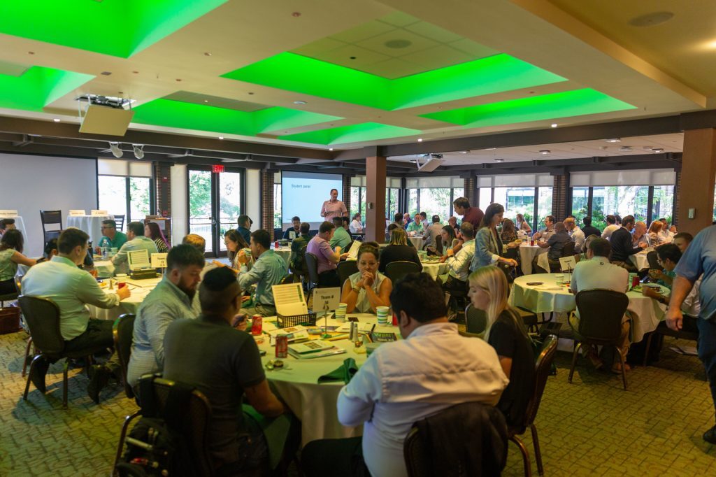 Executive MBA students fill a room in the Henry Center for an orientation event.