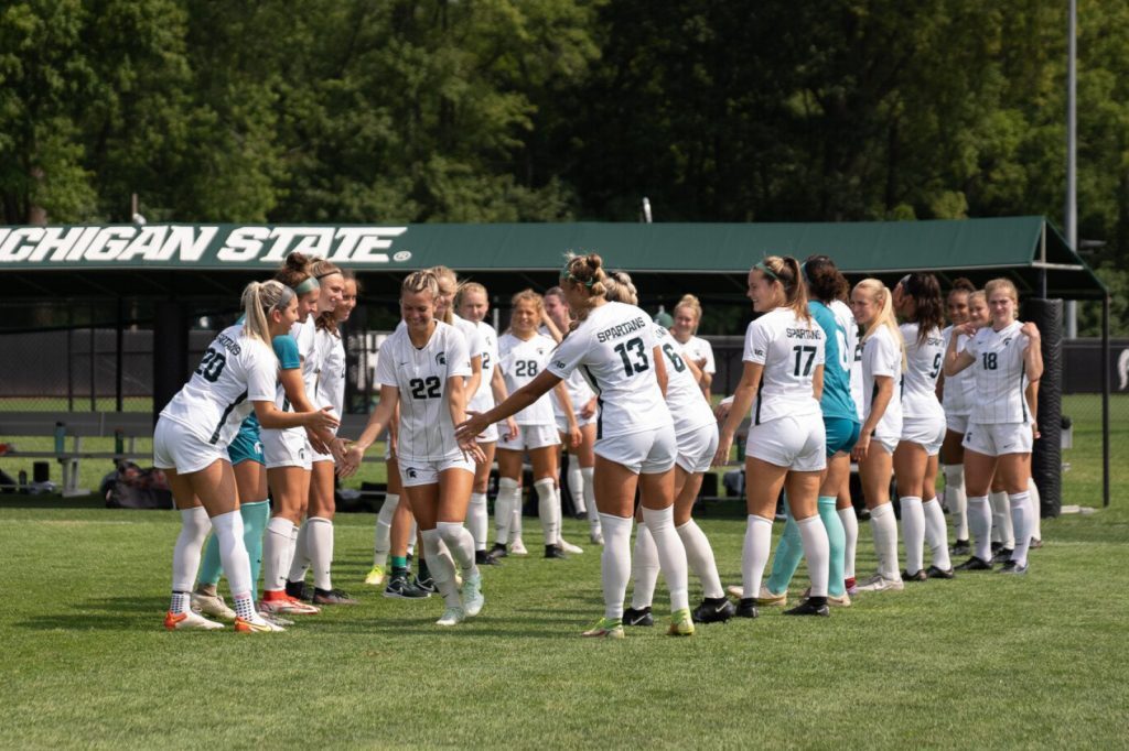 Abby Gardiner runs through a tunnel of her teammates on senior day
