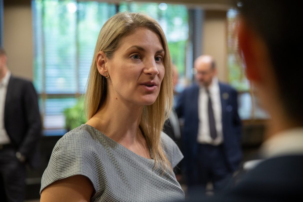 Chrissy Svejnar talks with someone about financial markets and institutions at an FMI board meeting.