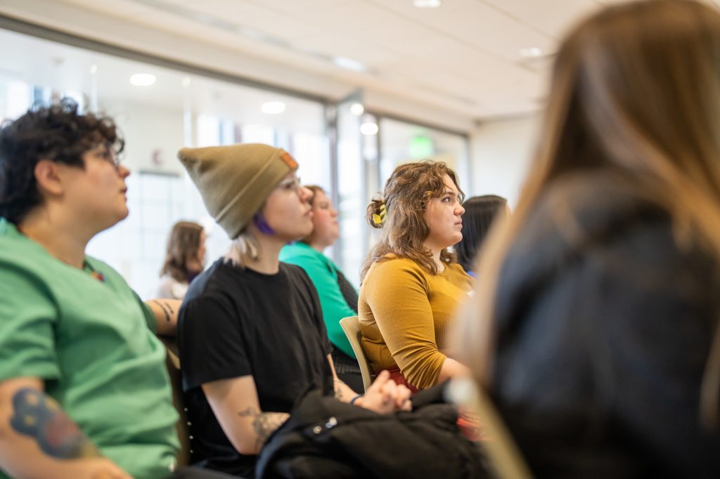 Young people sit and listen to presentations.