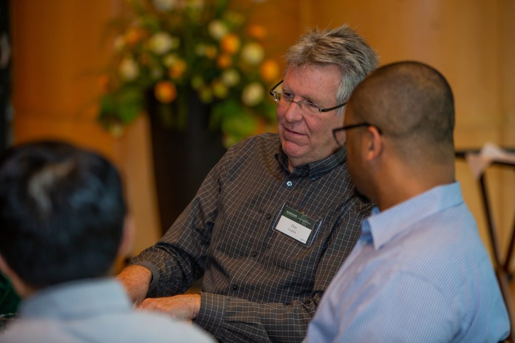 Don Conlon sitting and talking with a colleague.