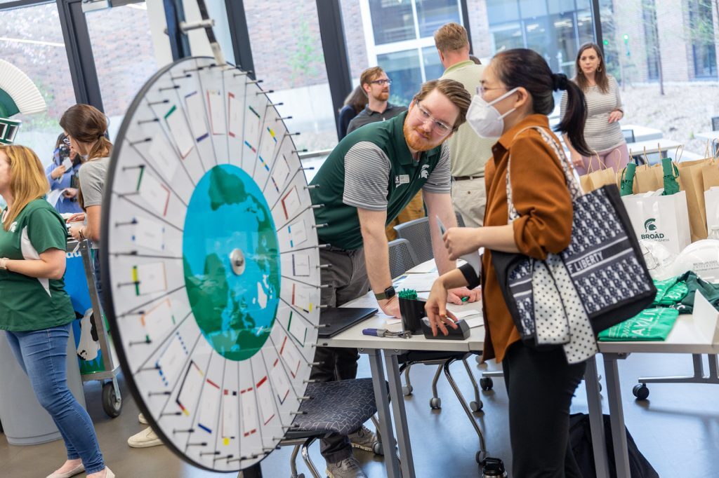 Broad College employees look at a prize wheel.