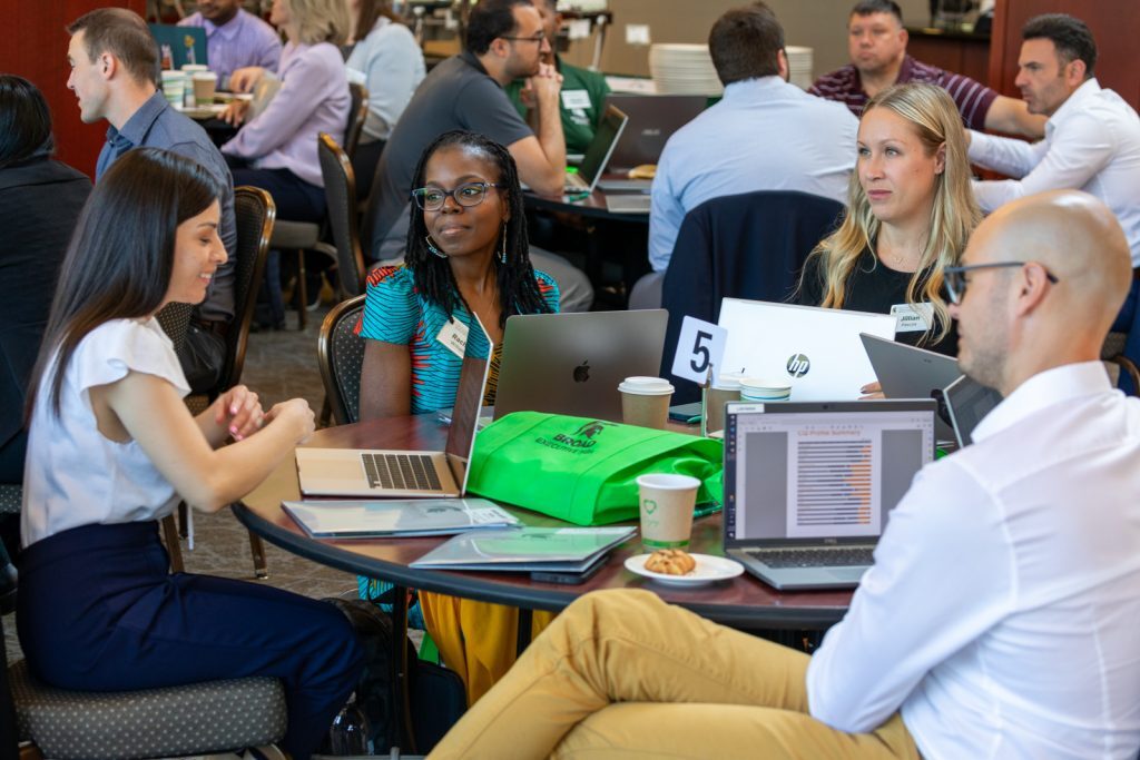 Executive MBA students get to know one another while seated at a table during orientation.