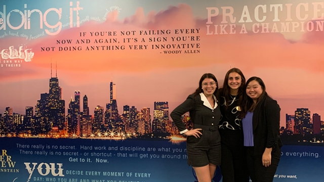 Gabriella Jensen posing with two others in front of a mural