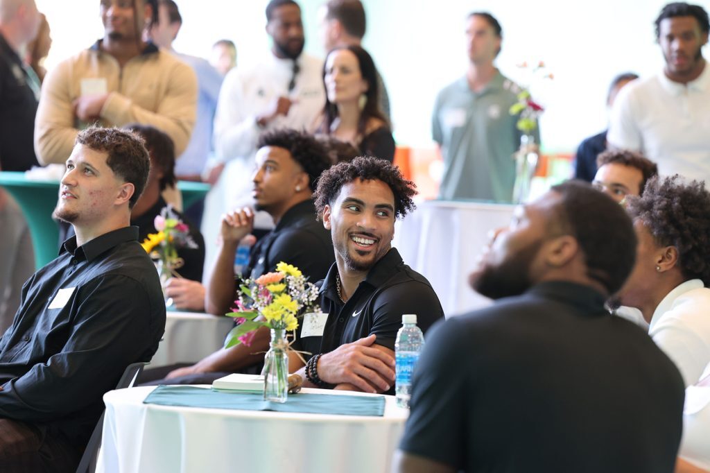 Students smile and talk while attending the MSU NIL Summit in the Minskoff Pavilion.