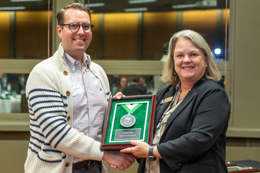 Nicholas Hays receives the Withrow Emerging Scholar Award from Interim Dean Whipple at the investiture ceremony.