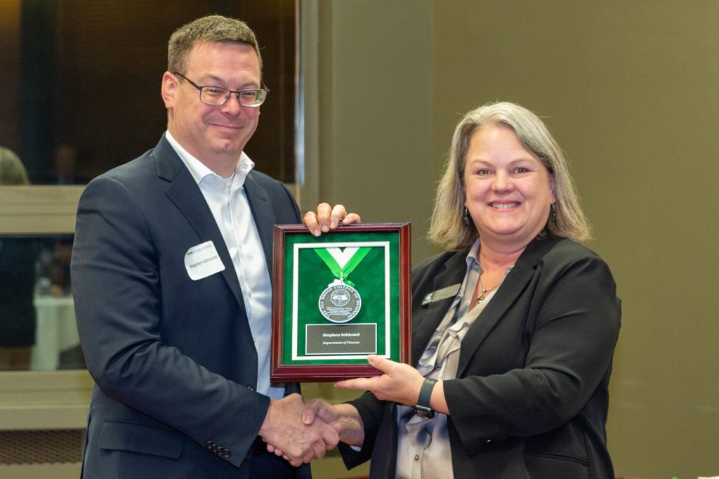 Stephen Schiestel receives the Withrow Distinguished Teaching Award from Interim Dean Judith Whipple at the investiture ceremony.