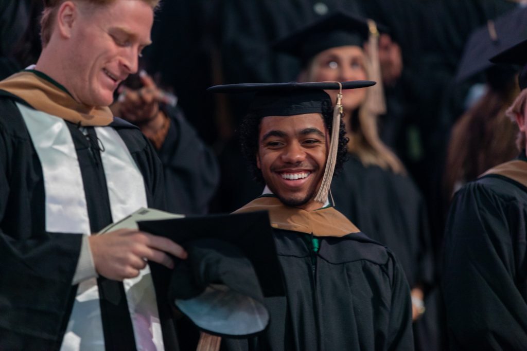 Advanced degree Broad Spartans smile while in the crowd at the Breslin Center.