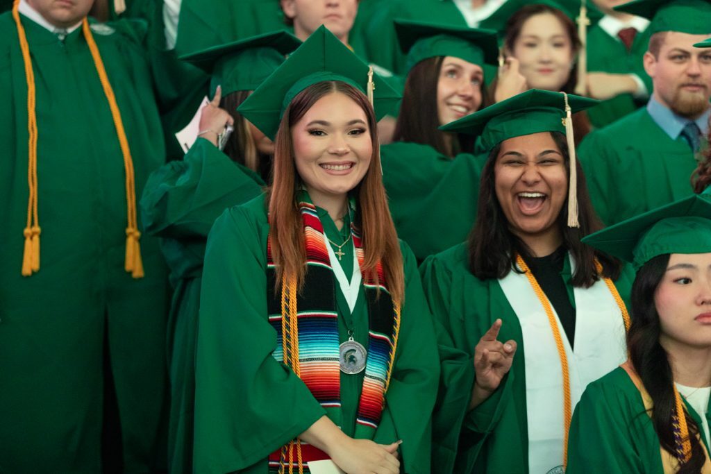 Two undergraduate Broad Spartan smile and pose for a picture at MSU Commencement 2023.