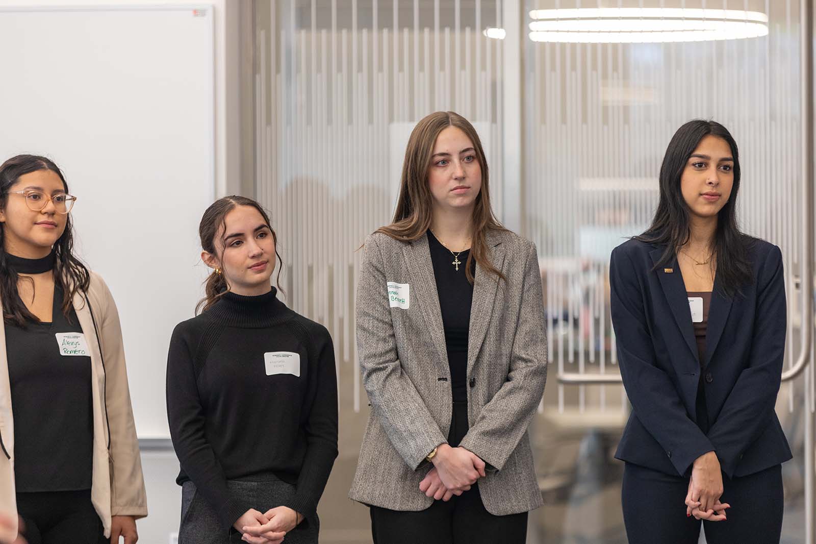 DWLA Scholars stand together and listen to someone speaking.