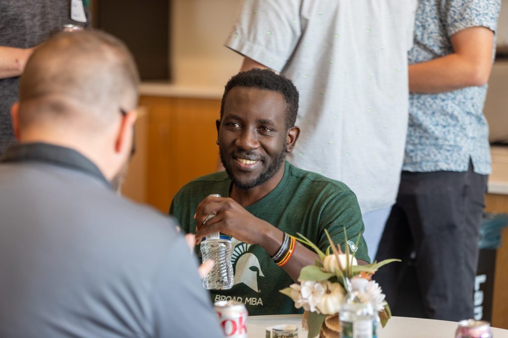 A Broad Spartan MBA student interacts with another person at a networking event.