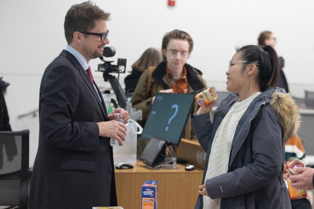 Yost speaks with a student after the presentation.