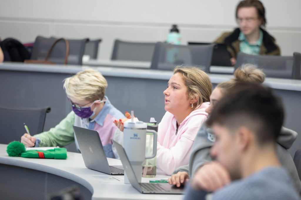 Students listen and take notes during the Kellanova company presentation.