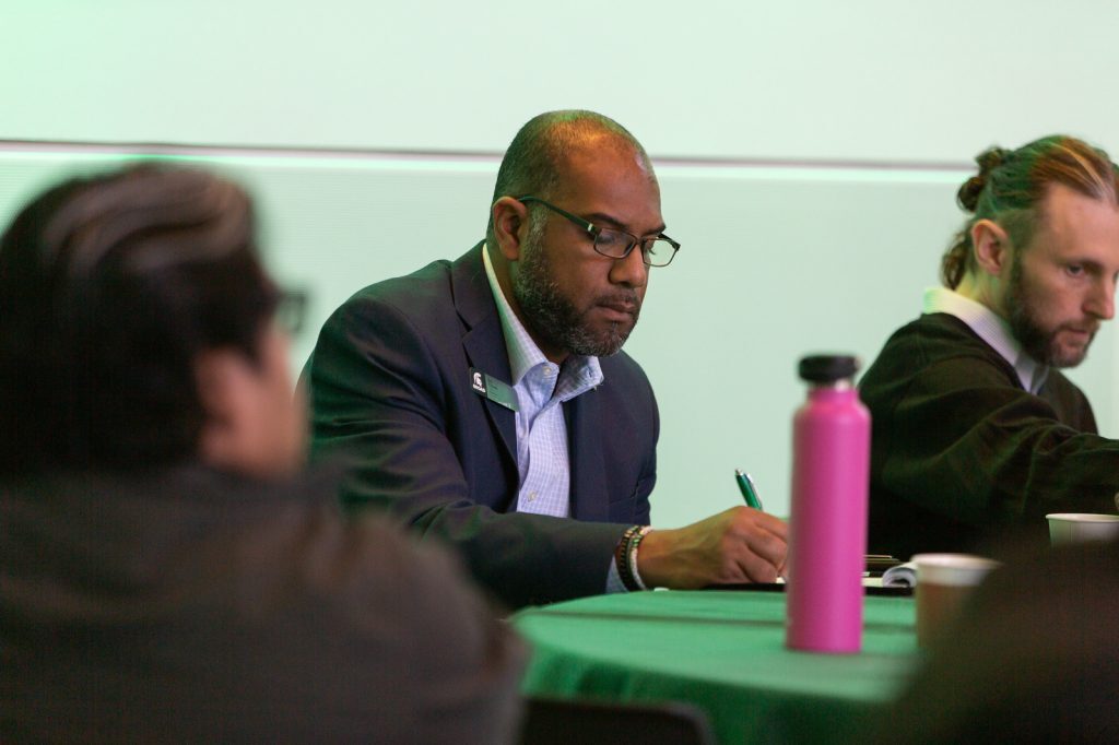 Ed Tillett takes notes at a college event.