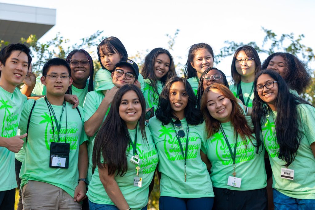 Students attending the 2022 Summer Business Institute pose for a picture in matching event T-shirts.