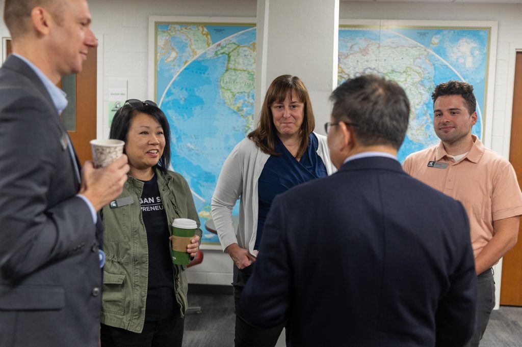 Group of five people standing and talking