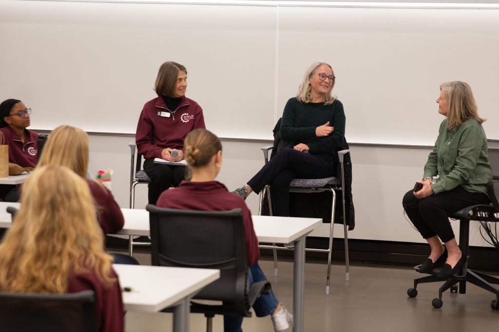 Panel of 3 women sitting in a panel in front of a classroom