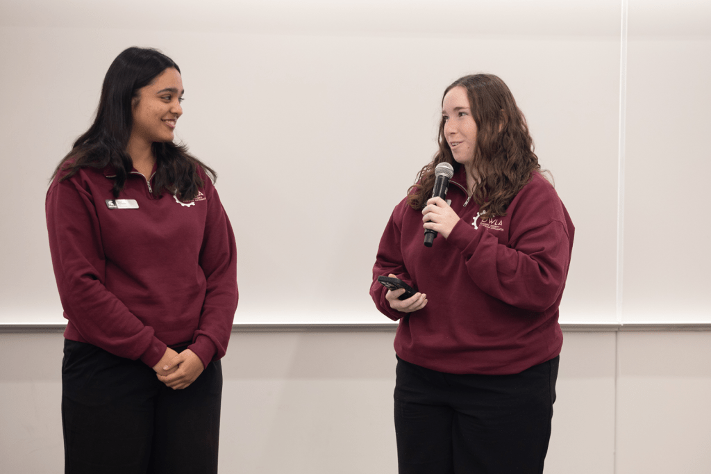 Two women speaking to each other with a microphone