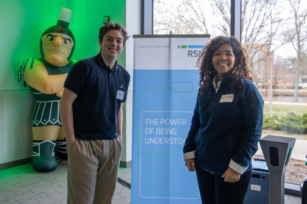 2 students standing near career fair sigh