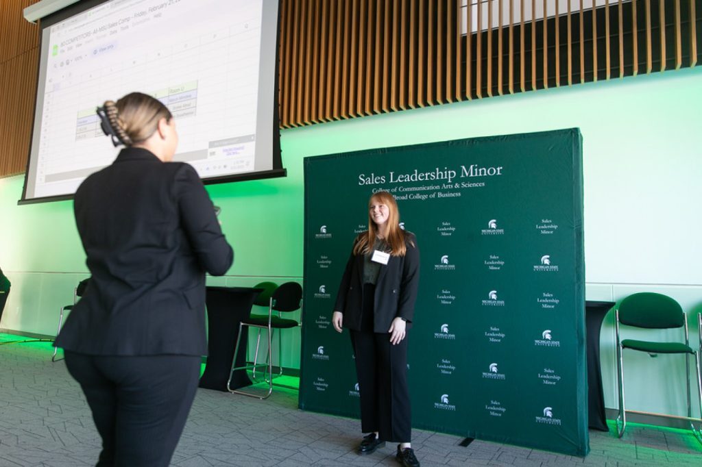 Students taking photos in front of Broad College of Business step and repeat.