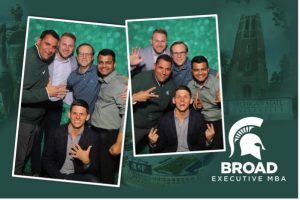 Group photo of EMBA students on MSU green background