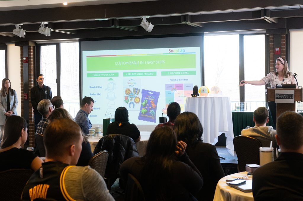 Student presenting to group of event attendees