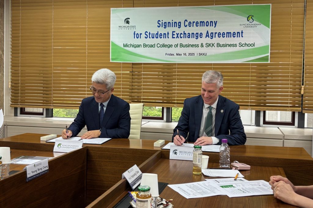 Business school deans signing paperwork
