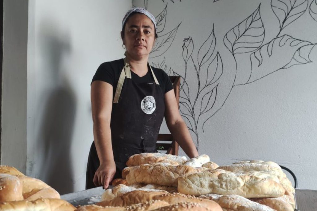 Woman standing with loaves of bread