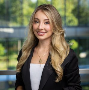 headshot of a woman with blonde hair wearing a black suit jacket