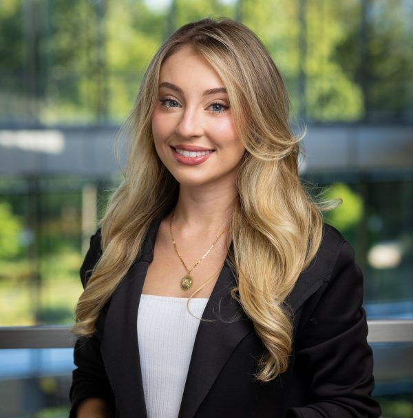 headshot of a woman with blonde hair wearing a black suit jacket