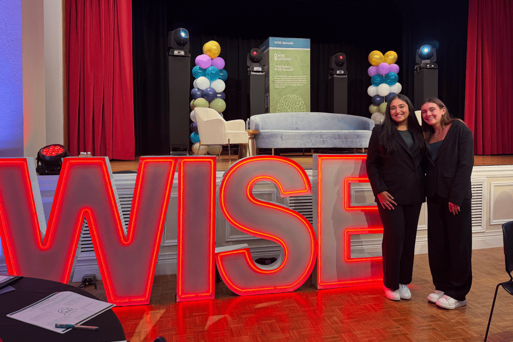 Students with WISE neon sign