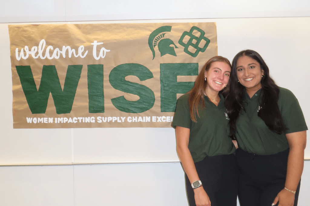 Rolison and Rana in front of WISE sign