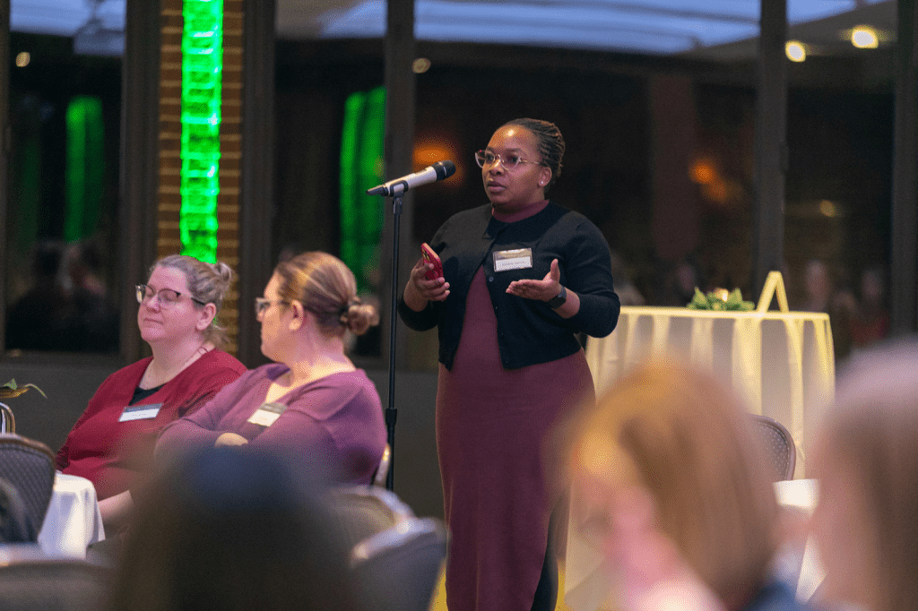 Person standing and speaking into microphone