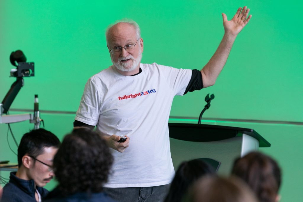 Brian Pentland presenting to group wearing a Fulbright Austria shirt