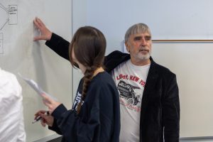 McCarthy gesturing to white broad next to student