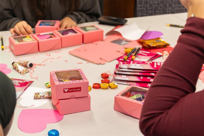 Pink boxes laid out on a table with craft supplies