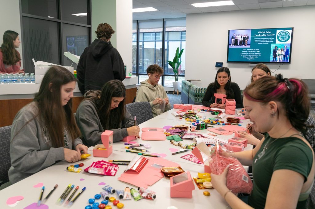 Students sitting around a table crafting