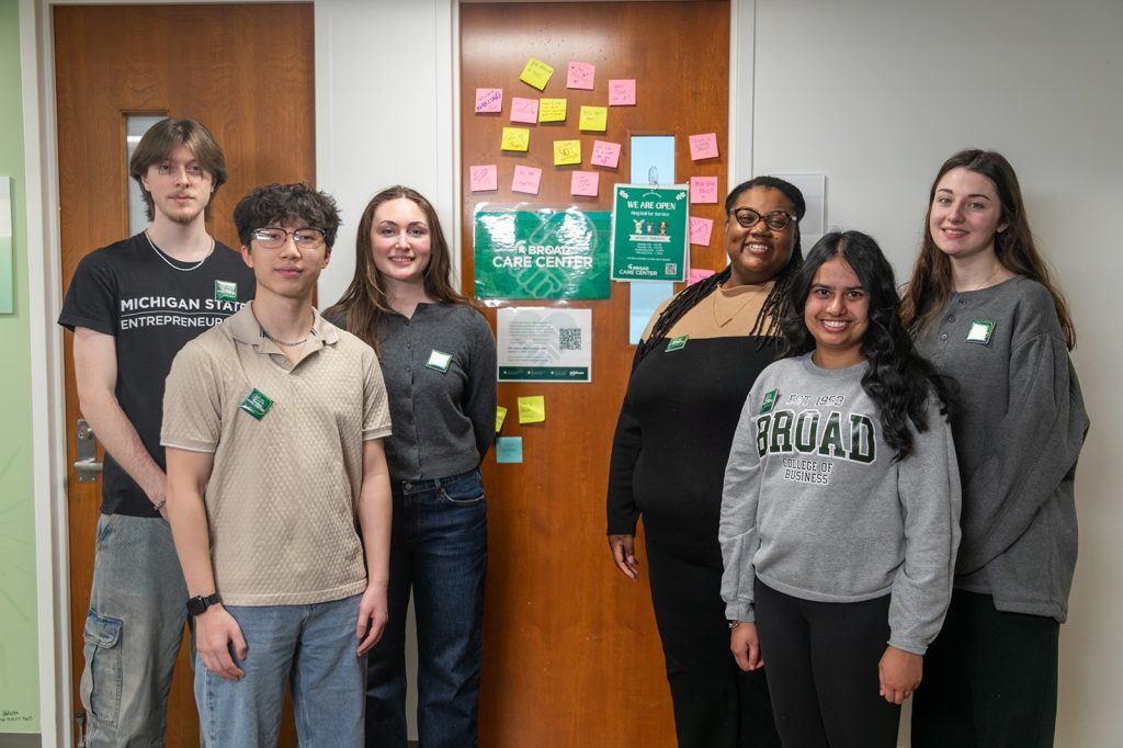 People standing for group photo in front of door